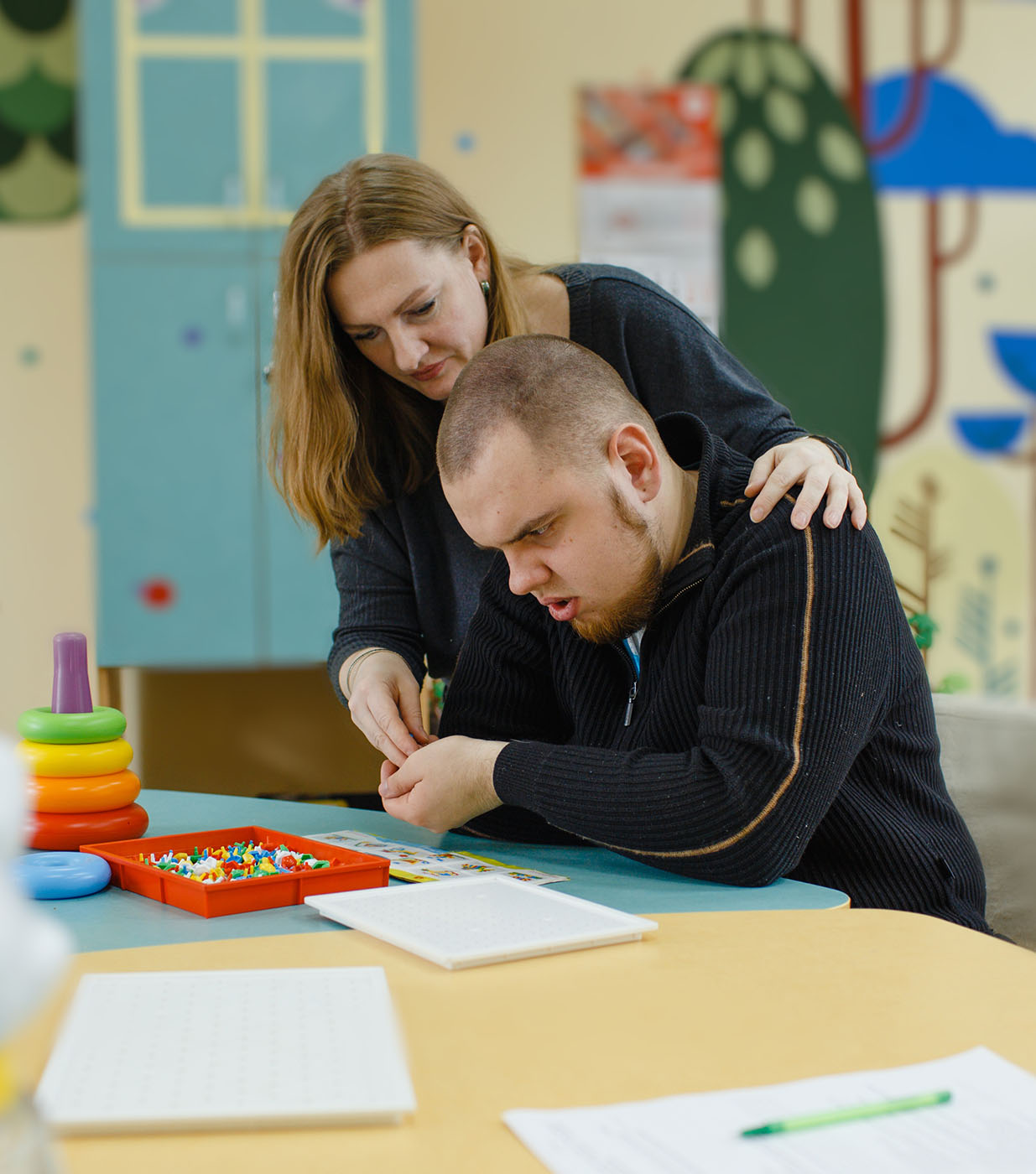 Support worker assisting an autistic adult within a supportive learning environment
